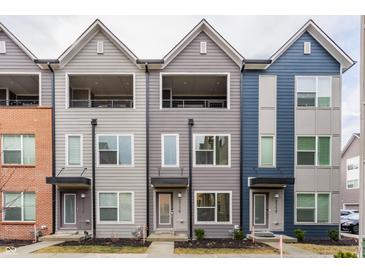 Modern townhome featuring varied neutral siding and individual entryways with small patios at 2115 Coretta Way, Indianapolis, IN 46202