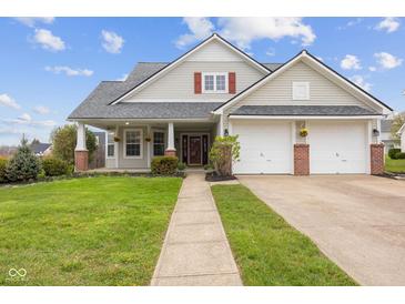 Charming home with a well-manicured lawn, attached two-car garage, and inviting front porch at 11130 Sanabria Dr, Indianapolis, IN 46235