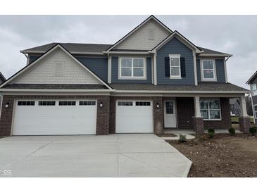 Charming two-story home with a brick and blue siding, complemented by a well-manicured lawn at 1265 Sika Ln, Greenwood, IN 46143