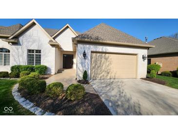 Charming white brick home with a well-manicured lawn and a beige garage door on a sunny day at 1655 Rosebud Ln, Greenwood, IN 46143