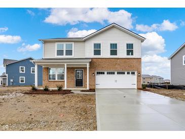 Inviting two-story home featuring a brick and vinyl facade, attached two-car garage, and a freshly poured concrete driveway at 2004 Foothill Dr, Greenfield, IN 46140
