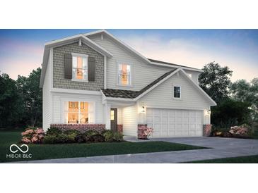 Charming two-story home featuring a two-car garage, landscaped yard, and a mix of siding and brick accents at 2134 Boxwood Dr, Greenfield, IN 46140