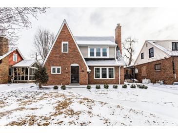Charming brick two-story home featuring a classic design and snow-covered front yard at 5715 N Delaware St, Indianapolis, IN 46220