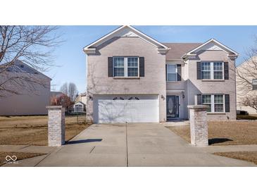 Two-story brick home featuring a two-car garage, double gable roof, and black shutters at 6236 White Rabbit Pl, Indianapolis, IN 46235
