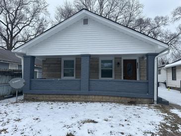 Charming single-story home with a covered front porch, stone accents, and wintery landscaping at 1105 Winfield Ave, Indianapolis, IN 46222