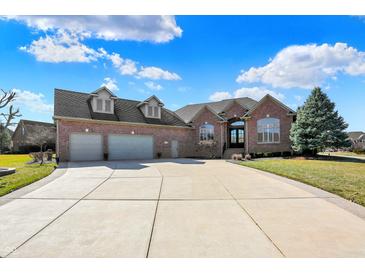Attractive brick house boasting a spacious driveway and a three-car garage on a lush, green lawn at 2110 Cheviot Ct, Greenwood, IN 46143