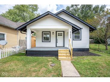 Charming home features a manicured lawn and inviting porch, with black and white trim at 509 St Paul St, Indianapolis, IN 46203