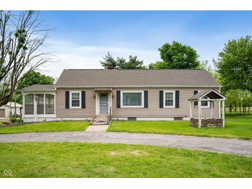 Charming ranch-style home with tan siding, neat landscaping, and a whimsical wishing well in the front yard at 9841 E Raymond St, Indianapolis, IN 46239