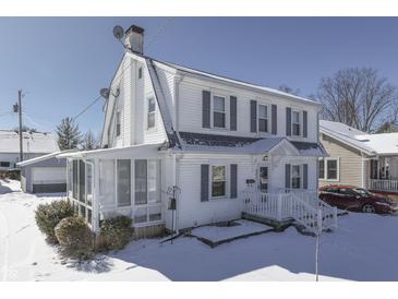 Charming two-story home with a white exterior, shutters, a screened-in porch, and snow-covered front yard at 221 Herriott St, Franklin, IN 46131