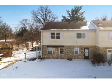 Two-story tan home with a stone facade, visible roof, set against a snowy front yard and blue sky at 2829 Country Estates Dr, Indianapolis, IN 46227