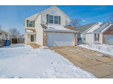 Charming two-story home with a two-car garage and a snow-covered front yard and driveway at 5638 Congressional Pl, Indianapolis, IN 46235