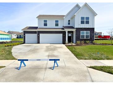 Two-story home featuring a brick and siding facade, two-car garage, and a well-manicured front lawn at 5879 Handbell Ln, Greenwood, IN 46143