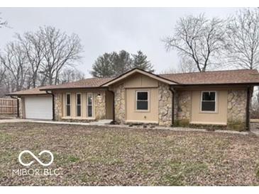 Charming ranch-style home featuring stone accents, attached two-car garage, and mature trees in the front yard at 229 Hillendale Dr, Greenwood, IN 46142