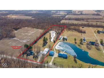 Aerial view of the property showcasing a large home, several outbuildings, a pond, and expansive acreage at 4981 E County Road 200 S, Avon, IN 46123