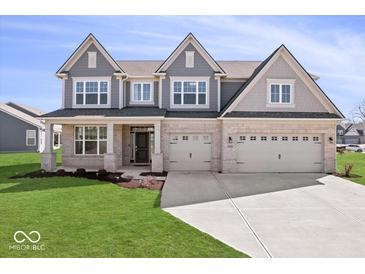 Beautiful two-story home featuring a three-car garage, light brick, grey trim, and a well-manicured lawn at 6723 Collisi Pl, Brownsburg, IN 46112
