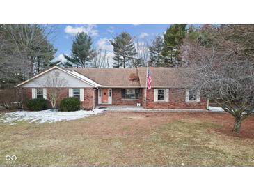Charming brick home features an inviting front yard and an orange front door at 11131 N State Road 9, Fountaintown, IN 46130
