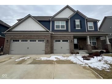 Charming two-story home featuring a two-car garage, brick facade, and blue siding at 1986 Mccormick Dr, Greenwood, IN 46143