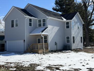 Two-story home featuring gray siding, an attached garage, and a welcoming front porch at 2819 Walker Ave, Indianapolis, IN 46203