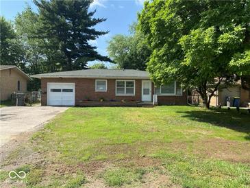 Charming brick ranch home featuring an attached garage, manicured lawn, and mature trees at 2863 W 30Th St, Indianapolis, IN 46222