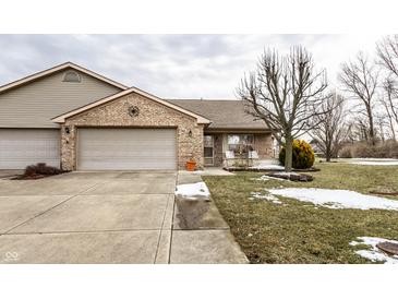 Cozy brick home featuring an attached two car garage and well maintained front yard and landscaping at 4033 Oak Trail Dr, Indianapolis, IN 46237