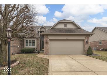 Charming single-Gathering home with a two-car garage, brick facade, and well-maintained lawn at 613 Brook Dr, Greenwood, IN 46143