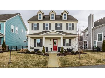 Charming two-story home boasts a welcoming front porch, a vibrant red front door, and well-manicured landscaping at 15432 Heatherbank Dr, Westfield, IN 46074