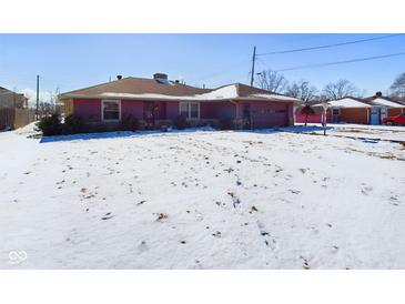 Charming single story home with attached garage and snow covered lawn at 2021 E 9Th St, Anderson, IN 46012