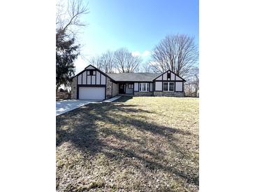 Charming home with a stone and tudor facade, set on a lush green lawn with mature trees at 2284 Horizon Blvd, Greenwood, IN 46143