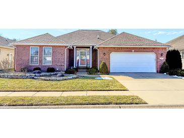 Charming single-story brick home featuring a manicured lawn and a two-car garage at 3681 S Station Dr, Columbus, IN 47203