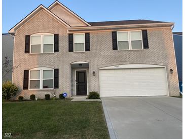 Charming two-story brick home with attached two-car garage and well-manicured lawn at 4067 Denali Dr, Indianapolis, IN 46235