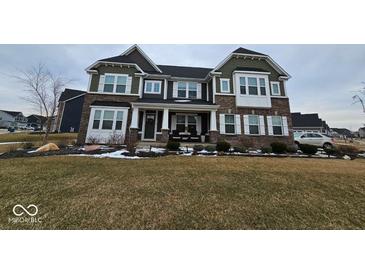 Charming two-story home with brick and siding exterior, covered porch, and manicured lawn at 12889 Girvan Way, Fishers, IN 46037