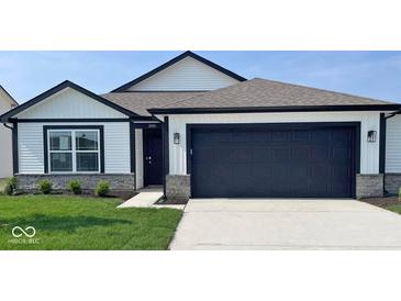 Charming single-story home featuring white siding, black accents, and a two-car garage on a sunny day at 1414 Bluebonnet Pl, Shelbyville, IN 46176