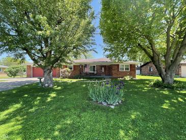 Charming brick home with well-maintained lawn, mature trees and flowerbeds enhancing the curb appeal at 2130 Theobald St, Shelbyville, IN 46176