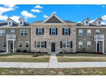 Charming townhome featuring light brick, black shutters, dormer windows, and well-maintained landscaping at 2792 Maricopa Blvd, Whitestown, IN 46075
