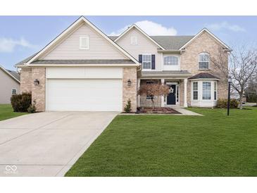 Charming two-story home with a well-manicured lawn, attached two car garage and beautiful brick and vinyl siding at 8654 Arailia Dr, Plainfield, IN 46168