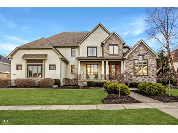 Beautiful two-story home featuring manicured lawn, stone accents, and welcoming covered porch at 11573 Bent Tree Ct, Zionsville, IN 46077