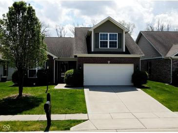Charming home featuring a two-car garage, manicured lawn, and traditional architectural details at 1223 Blackthorne S Trl, Plainfield, IN 46168
