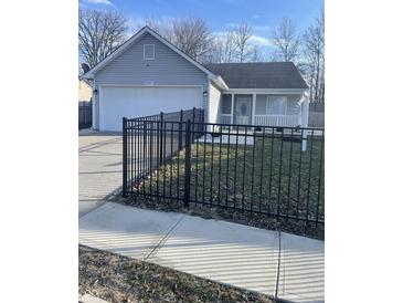 Charming single-story home with gray siding, a black metal fence and well-maintained lawn at 2027 E Werges Ave, Indianapolis, IN 46237