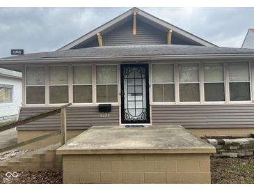 Charming home featuring a decorative front door, neutral siding, and a welcoming entrance platform at 2122 George St, Anderson, IN 46016