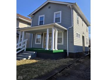 Charming two-story home with a covered front porch and classic architectural details at 721 N Grant Ave, Indianapolis, IN 46201