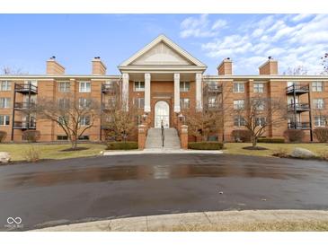 Beautiful brick condo building with columns, a front lawn and dark-paved entrance at 8751 Jaffa Court E Dr # 17, Indianapolis, IN 46260