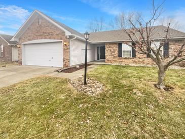 Charming home featuring a two-car garage, brick facade, and a well-manicured front yard at 12840 Patrick Ct, Fishers, IN 46038