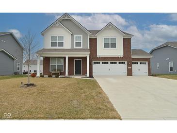 Charming two-story home with brick and siding, attached three car garage and well-manicured lawn at 1307 Peregrine Ln, Greenwood, IN 46143