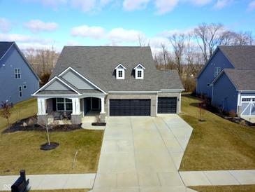 Beautiful aerial view of home with a three-car garage, nice landscaping, and inviting front porch at 14904 Tiago Ln, Fishers, IN 46040