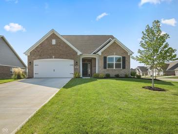 Charming brick home featuring an attached two car garage and manicured lawn at 1692 S Centennial Ave, New Palestine, IN 46163