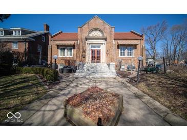 Charming brick home with a landscaped front yard, red roof, and grand entrance with beautiful steps at 198 E Madison St, Franklin, IN 46131