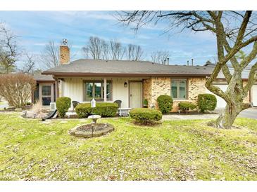 Charming single-story home featuring a brick facade, well-maintained landscaping, and inviting front porch at 2456 N Willow Way, Indianapolis, IN 46268