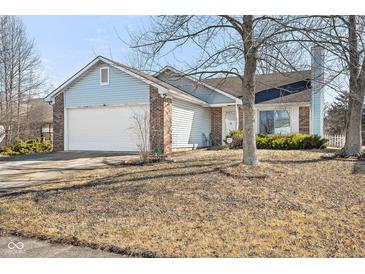 Charming home with a two-car garage, brick accents, light blue vinyl siding, and a well-manicured front yard at 3121 River Birch Dr, Indianapolis, IN 46235
