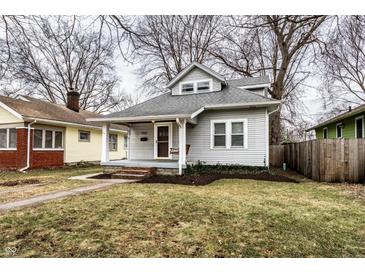 Charming gray home with a cozy front porch, mature trees, and well-maintained lawn at 5432 Winthrop Ave, Indianapolis, IN 46220