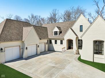Stunning white brick home featuring a spacious driveway, attached garages, and manicured lawn at 580 Exmoor Dr, Carmel, IN 46032